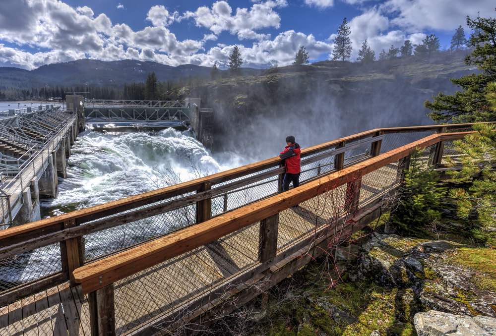 Cascading water beneath a dam creates a damp environment for commercial roofing