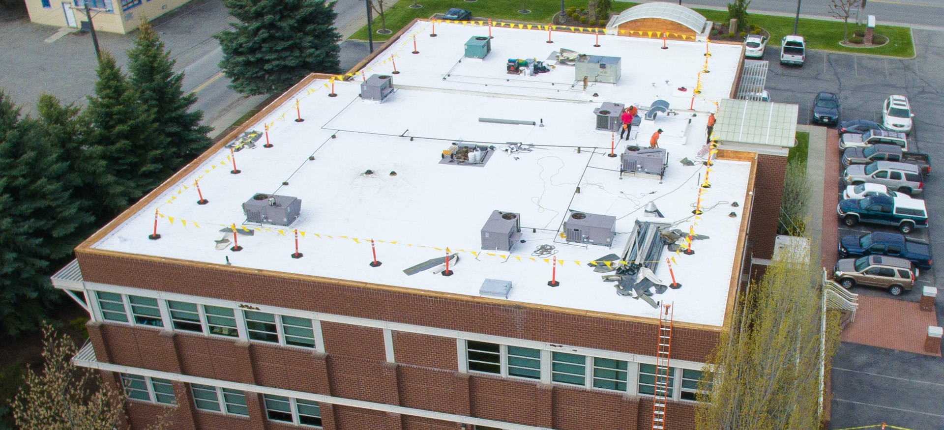 Commercial Flat Roof Replacement Crew Working Safely And Efficiently - Aerial View